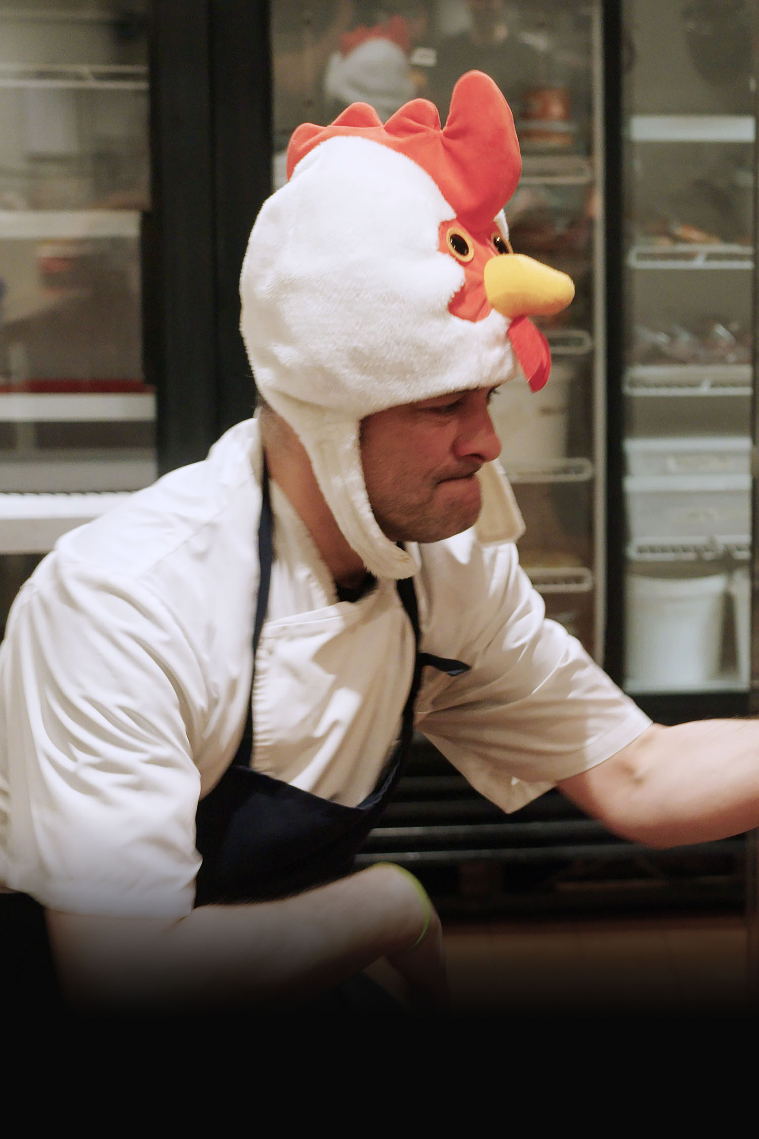 Charles-Antoine Crête en costume de poulet cuisine avec des flammes.